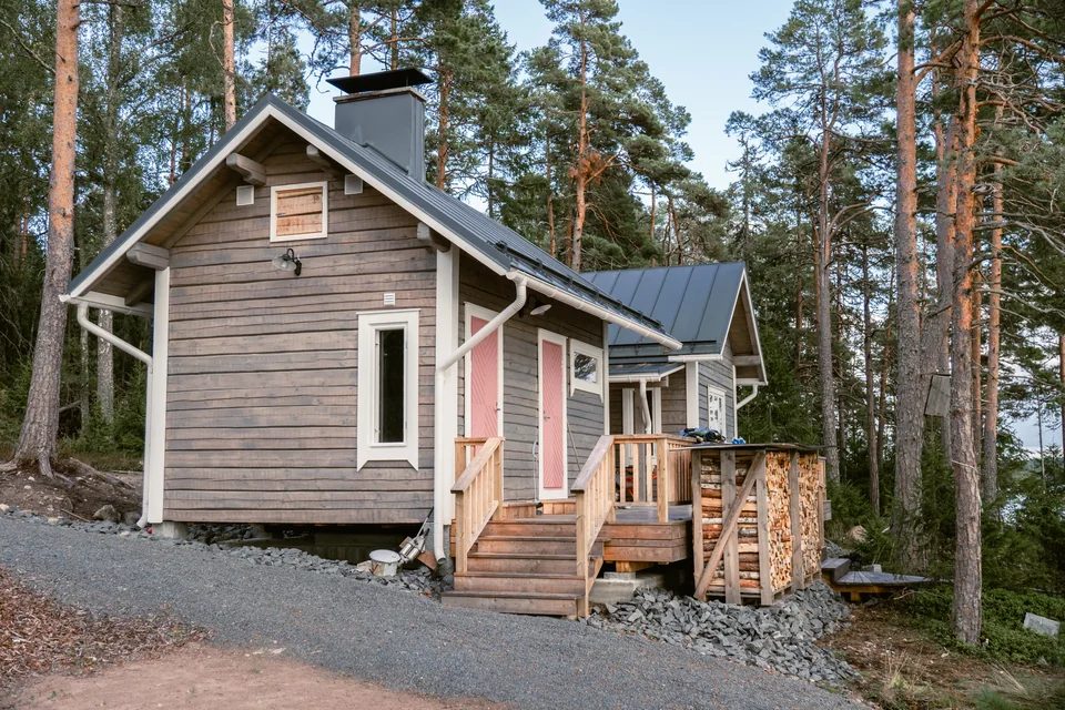 Pieni hirsirakennus mäntymetsässä