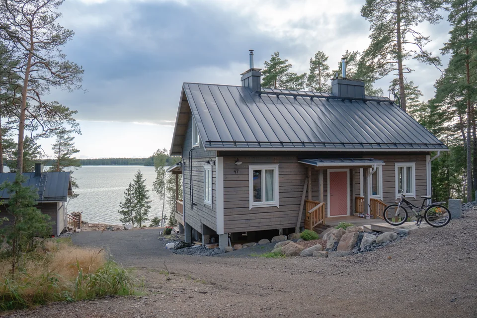 Hirsirakennus metsän ja veden äärellä